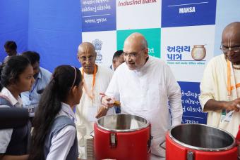 The Chief Guest serves nutritious mid-day meals to school children