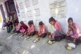 Freshly cooked ‘Khichdi’ is served to children